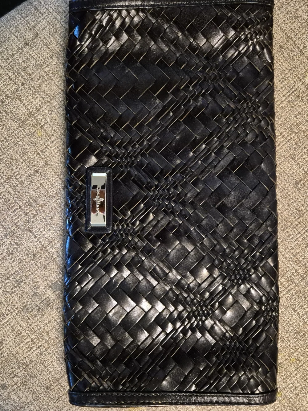 Cole Haan woven black leather clutch featuring a silver-tone logo emblem.